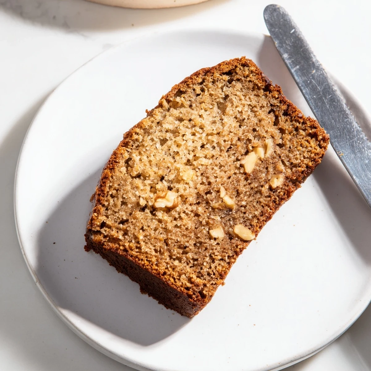 Warm, golden Simple Banana Bread loaf, with visible moist crumbs, ready for slicing and enjoying.