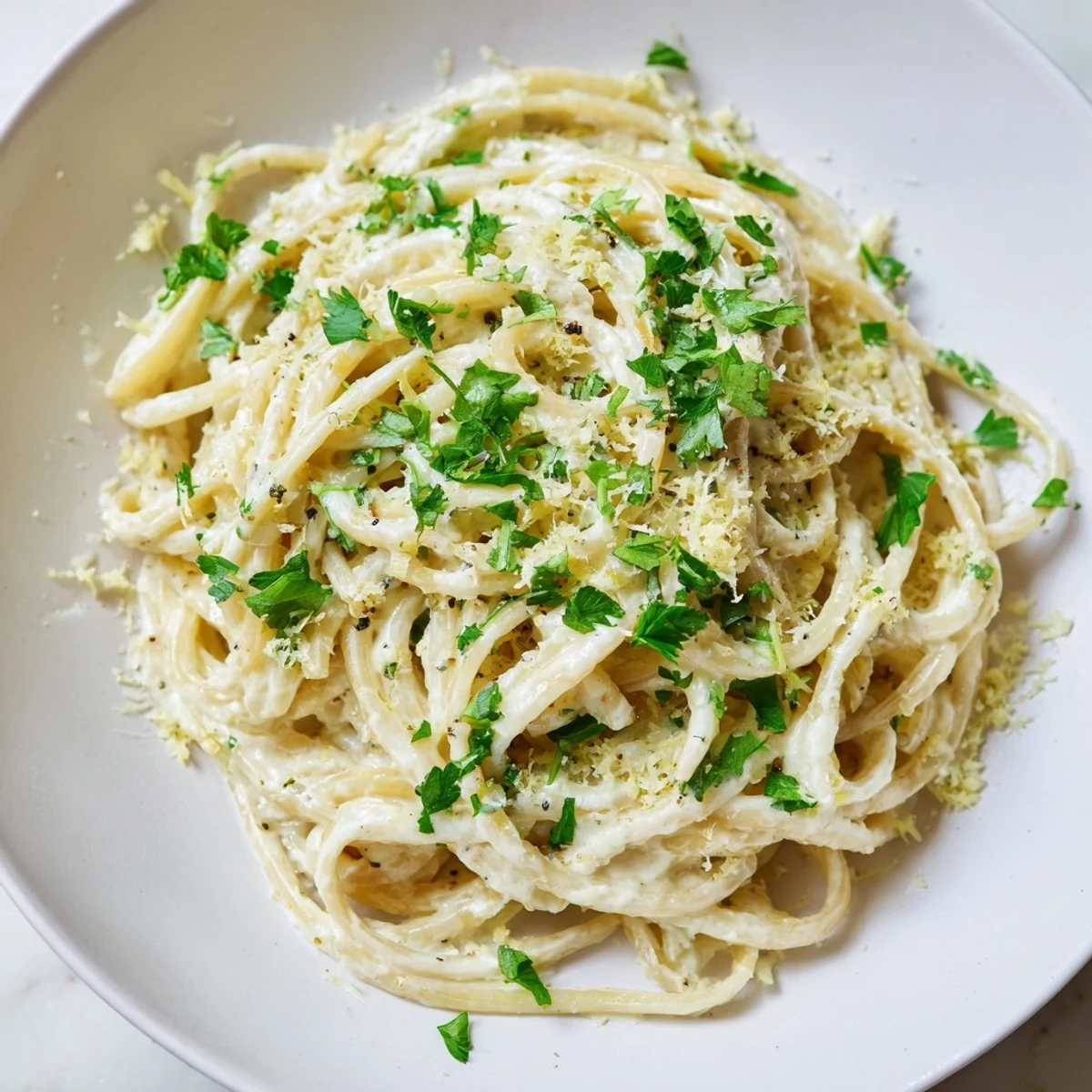 Creamy Lemon-Garlic Greek Yogurt Pasta, ready to devour, garnished with fresh parsley and lemon wedges.