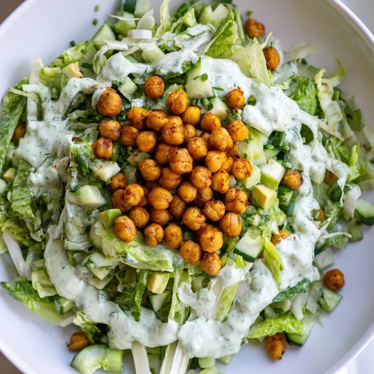 Close-up of a refreshing Green Goddess Salad showcasing vibrant veggies and crunchy chickpeas.