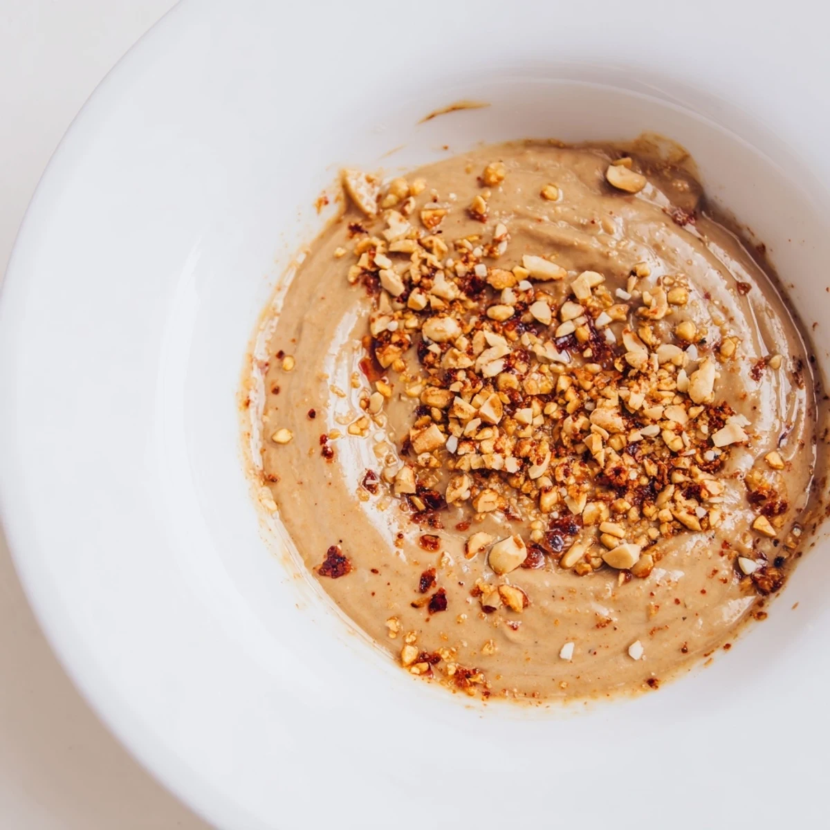 Vibrant photo reveals aromatic Indonesian satay sauce, ready to be poured generously over grilled satay skewers.