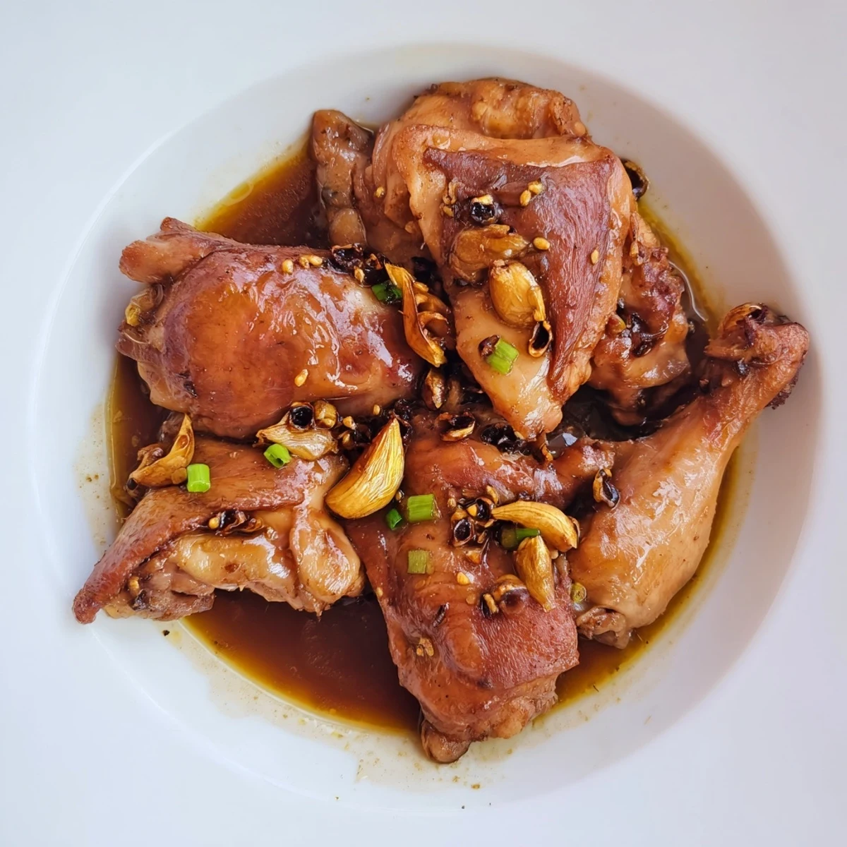 Tender Filipino Chicken Adobo, glistening in a savory sauce, ready to be served with fluffy rice.
