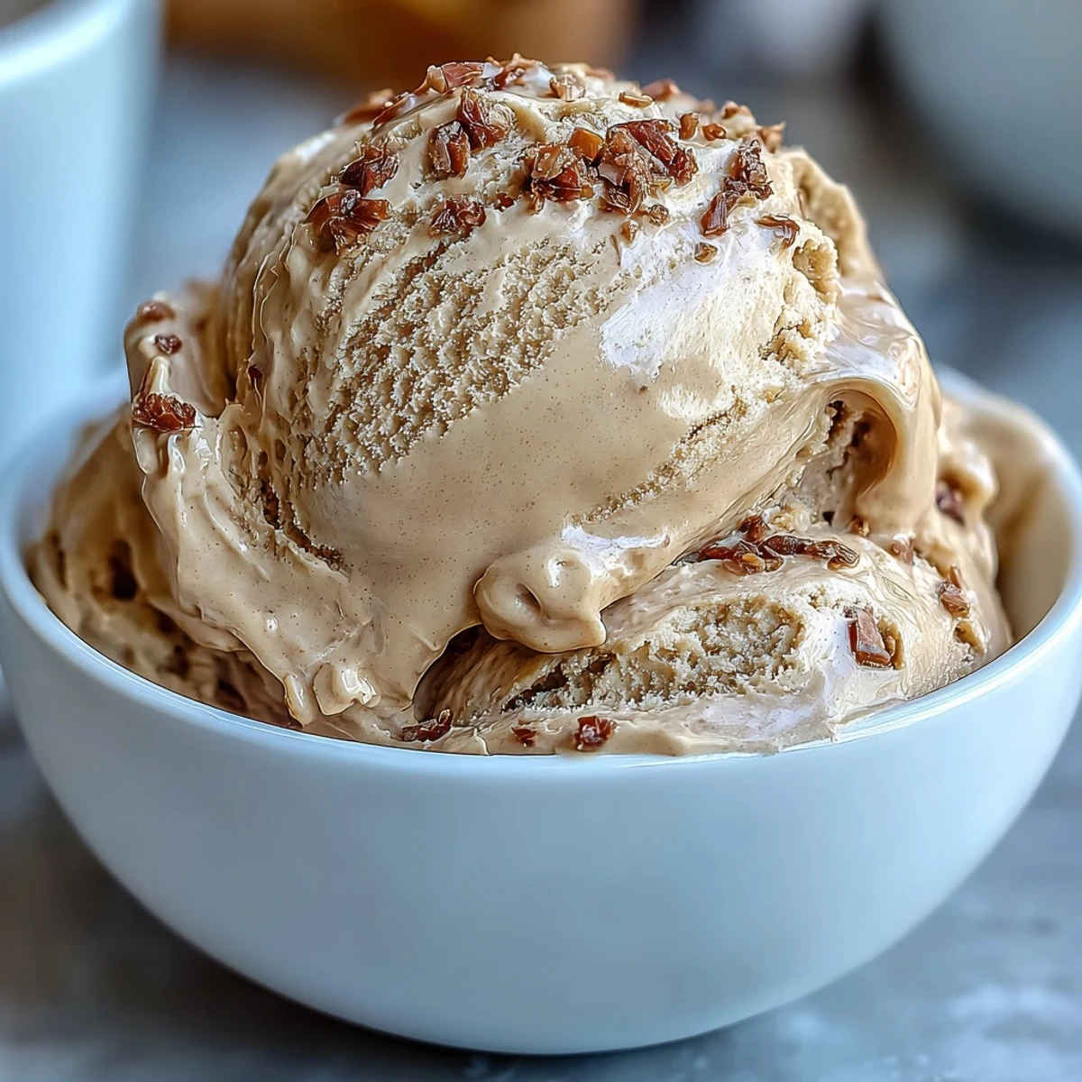 A close-up of homemade Hojicha ice cream in a ceramic bowl, garnished for a Japanese dessert.