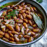 Tender simmered pinto beans in a savory broth, perfect for spooning into tacos or topping nachos.