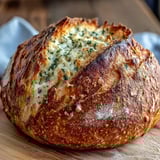 Slices of warm Perfect Parmesan Garlic Artisan Bread reveal a soft, garlicky crumb beside a steaming bowl of soup.