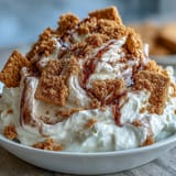 Easy no-bake cheesecake dip with cream cheese and whipped cream, perfect for parties, served with sweet graham cracker sticks.