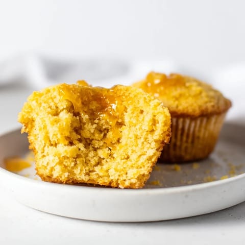 Warm and delicious honey butter cornbread muffins, ready to serve with a drizzle of honey and butter.