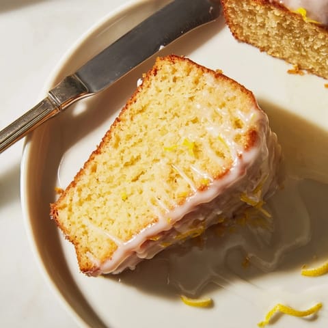 A slice of fresh lemon yogurt cake, showcasing its moist texture and tangy flavor, ready to serve.