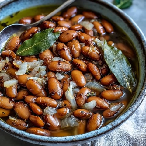 Tender simmered pinto beans in a savory broth, perfect for spooning into tacos or topping nachos.