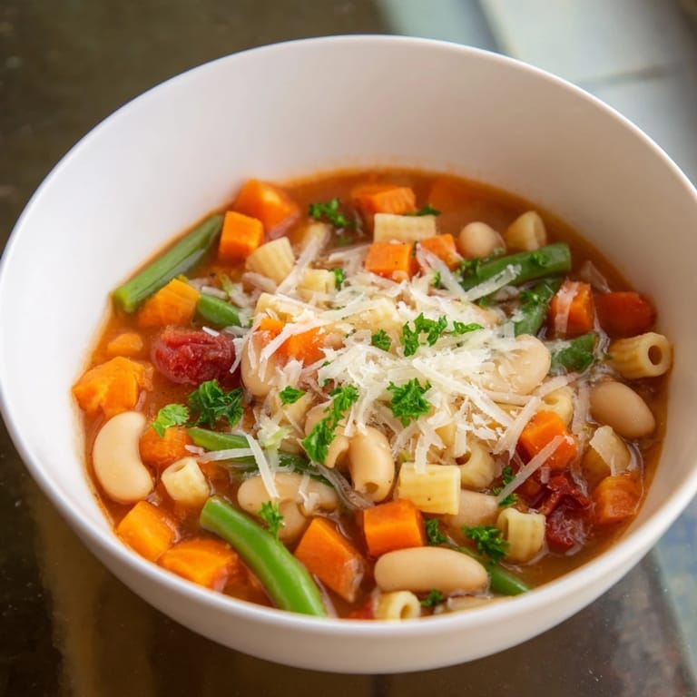 A rustic bowl of Simple One-Pot Minestrone Soup: savory vegetables and pasta in a rich tomato broth.