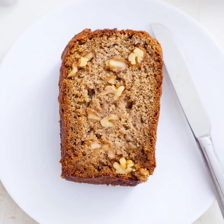 Slice of freshly baked Simple Banana Bread, showing a soft, inviting crumb texture, perfect morning snack.