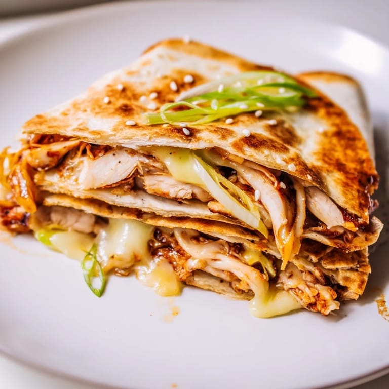 Savory Korean BBQ chicken grilled cheese wrap with melted cheese, scallions, and sesame seeds, a comforting meal.