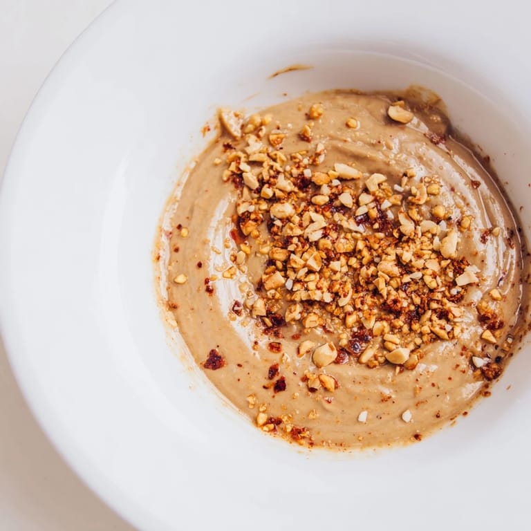 Vibrant photo reveals aromatic Indonesian satay sauce, ready to be poured generously over grilled satay skewers.