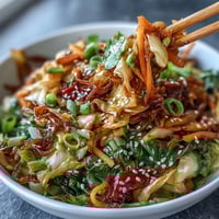 Spicy cabbage stir fry with garlic, ginger, and chili, wok-tossed until crisp-tender and glossy.